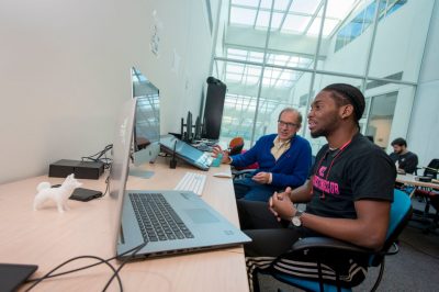 Professor Phillip Bradford meeting with a student about his computer science project at Uconn Stamford on Oct. 17, 2018. (Sean Flynn/UConn Photo)